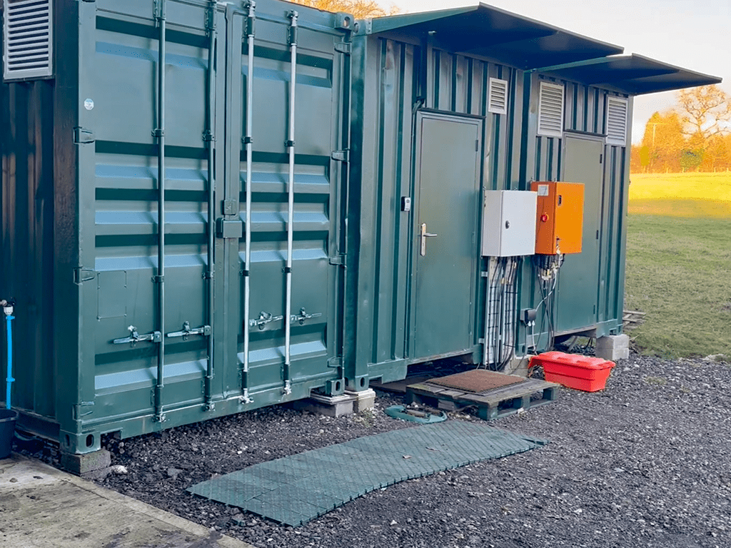 External view of two large green insect farming containers at the Flybox Chesham facility