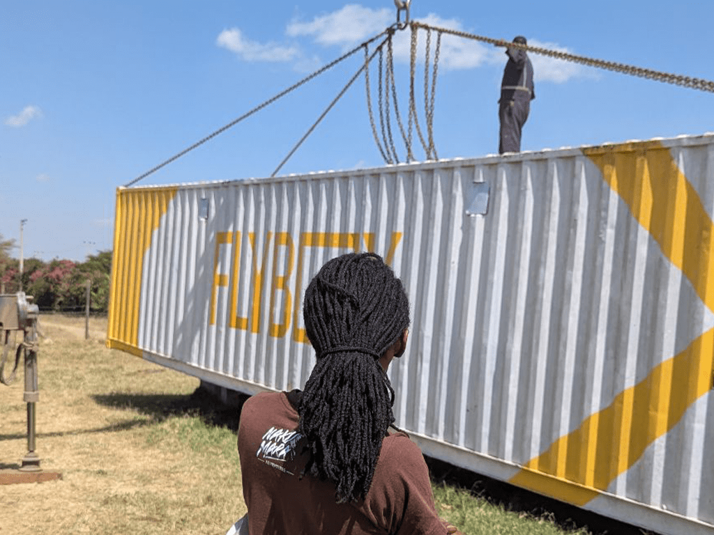 A large white and yellow insect farming container being offloaded at the Flybox Kenya facility