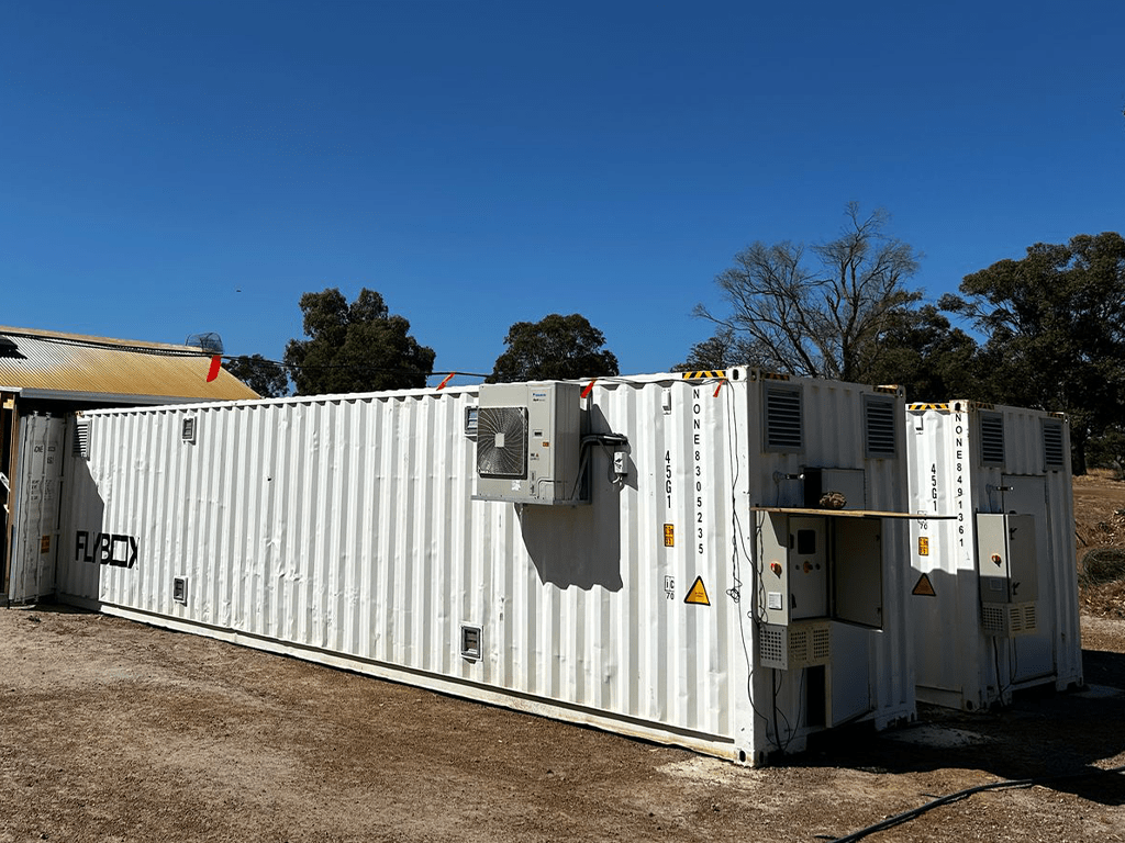 Two large white insect farming containers on site at a waste management facility